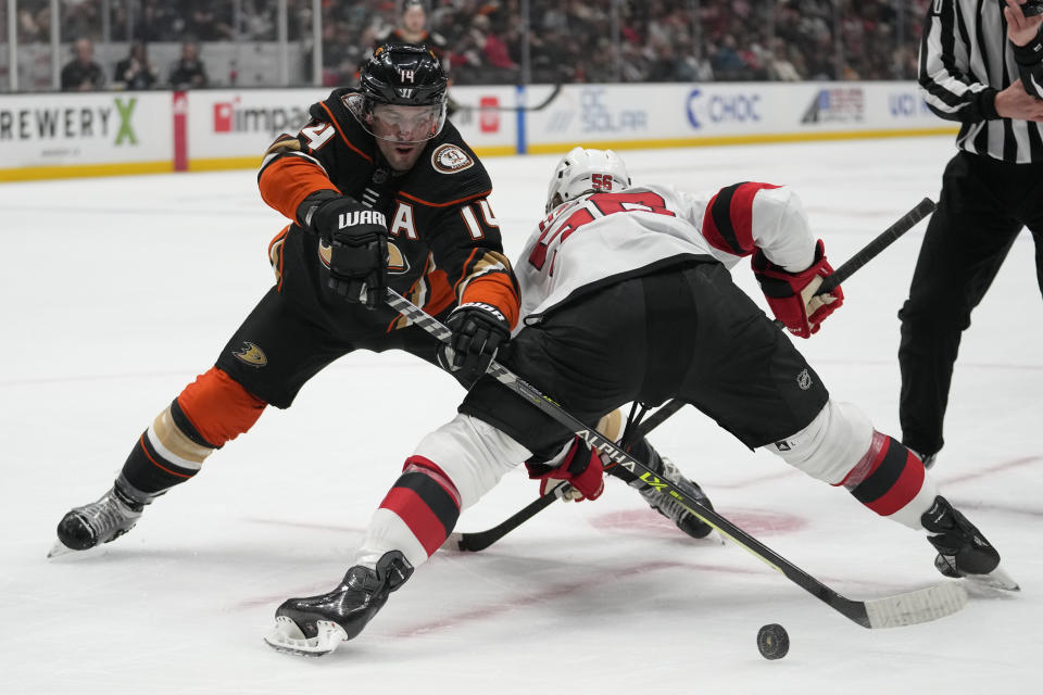 Anaheim Ducks center Adam Henrique (14) takes control of the puck from New Jersey Devils left wing Erik Haula (56) during the first period of an NHL hockey game in Anaheim, Calif., Friday, Jan. 13, 2023. (AP Photo/Ashley Landis)