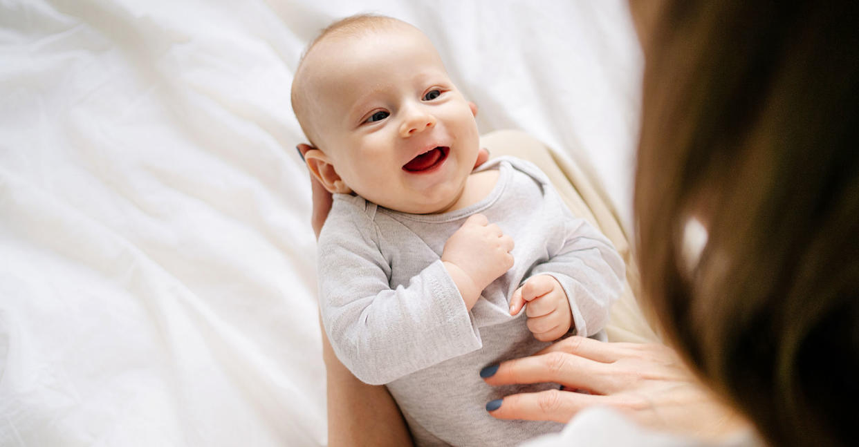 Little newborn baby boy relaxing on woman hands in bed (Tatiana Meteleva / Getty Images)