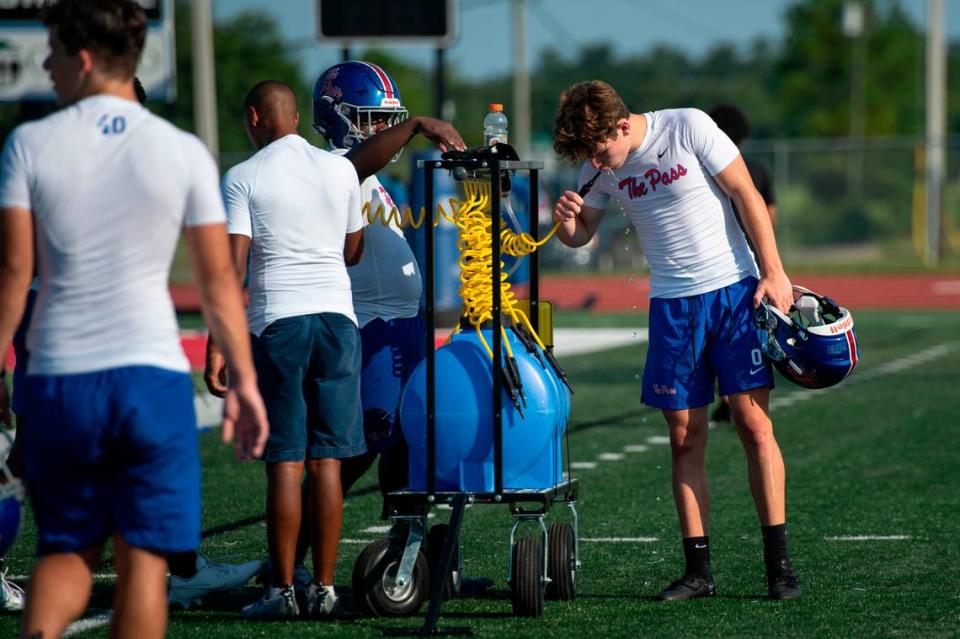 Pass Christian football players take a water break during practice at Francis McDonald Stadium in Pass Christian on Tuesday, Aug. 1, 2023.