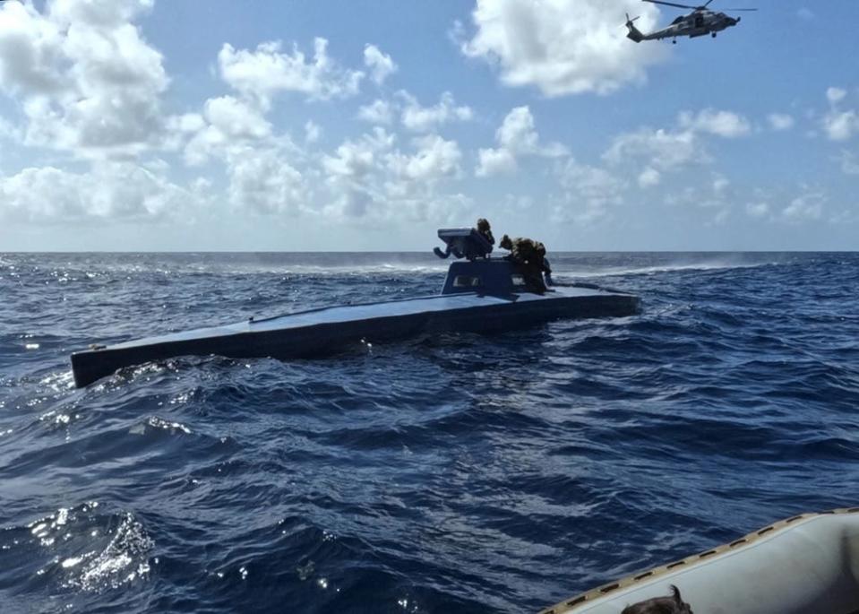 US Coast Guard and US Navy sailors work together to intercept a self-propelled semi-submersible drug smuggling vessel