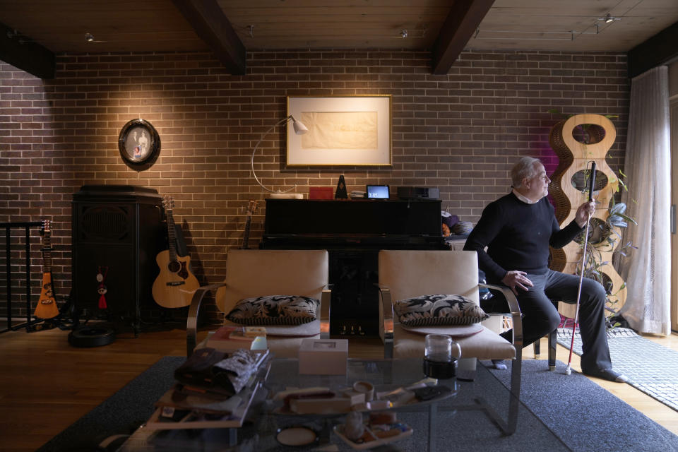 Architect John Gleichman, who suffers from a rare eye disease that left him legally blind, sits for a portrait at his home Monday, May 1, 2023, in Chicago. Gleichman was struck by a taxicab while walking home near Chicago's Lincoln Park Zoo, the same intersection where a 4-year-old girl would later be killed by a hit-and-run driver who sped through a stop sign. (AP Photo/Charles Rex Arbogast)