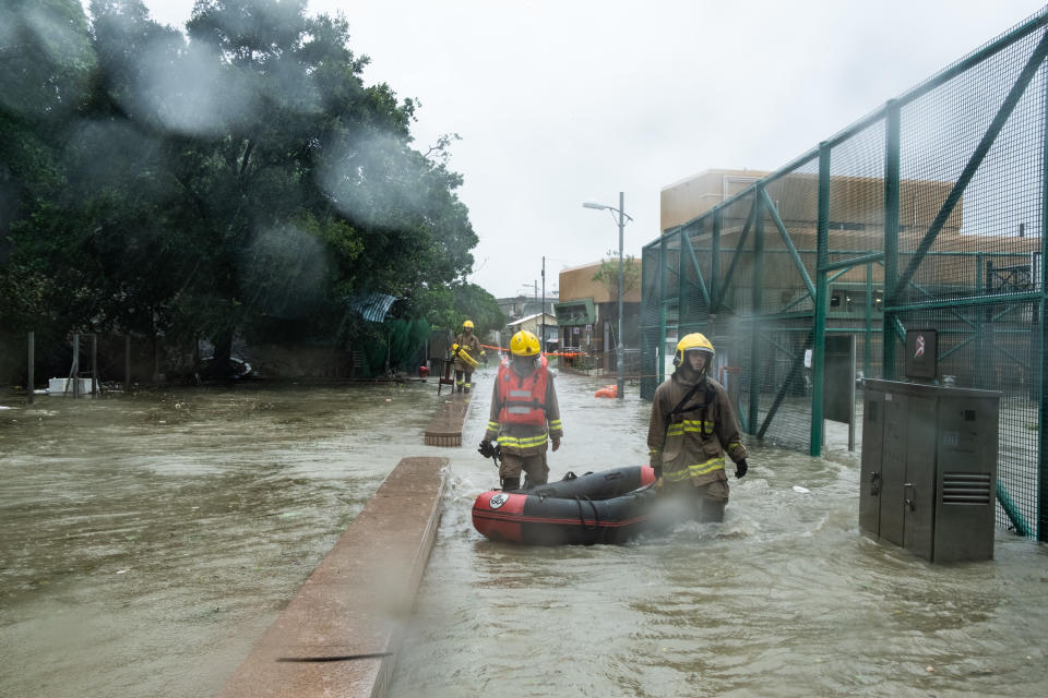消防員在颱風吹襲本港當日，出動救生艇在一個村進行救援行動。 (Photo by Lam Yik Fei/Getty Images)
