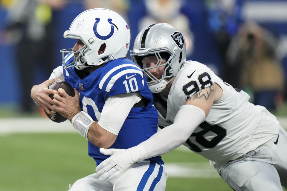 Indianapolis Colts quarterback Gardner Minshew (10) is tackled by Las Vegas Raiders defensive end Maxx Crosby (98) during the first half of an NFL football game Sunday, Dec. 31, 2023, in Indianapolis. (AP Photo/AJ Mast)