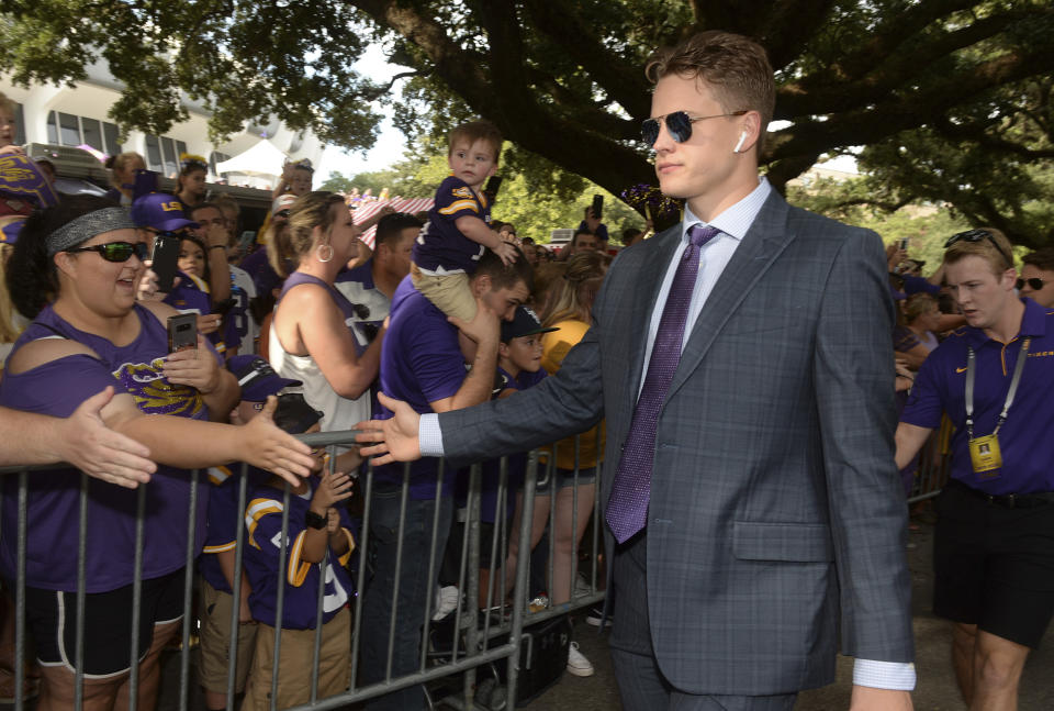 LSU quarterback Joe Burrow greets fans as he and the team walk down the hill to Tiger Stadium before an NCAA college football game against Northwestern State, Saturday, Sept. 14, 2019, in Baton Rouge, La. (AP Photo/Patrick Dennis)