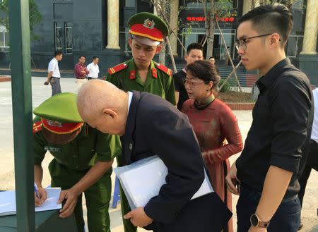 Policemen stop and check papers of Le Thi Minh Ha (2nd R), wife of Vietnamese prominent blogger Anh Ba Sam whose real name is Nguyen Huu Vinh, Vinh's lawyer Tran Van Tao (2nd L) and Vinh's son Nguyen Huu Phuc (R), before his appeal trial and of Vinh's assistant Nguyen Thi Minh Thuy in Hanoi, Vietnam September 22, 2016. REUTERS/Nguyen Tien Thinh