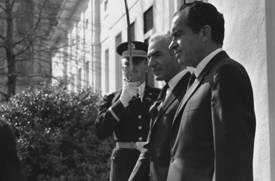FILE - In this April 1, 1969 file photo, an unidentified U.S. Army officer salutes as the Shah of Iran Mohammad Reza Pahlavi, center, and President Richard Nixon, walk past, on the White House grounds in Washington. The fall of the Peacock Throne and the rise of the Islamic Revolution in Iran grew out of the shah’s ever-tightening control over the country as other Middle East monarchies toppled. (AP Photo, File)