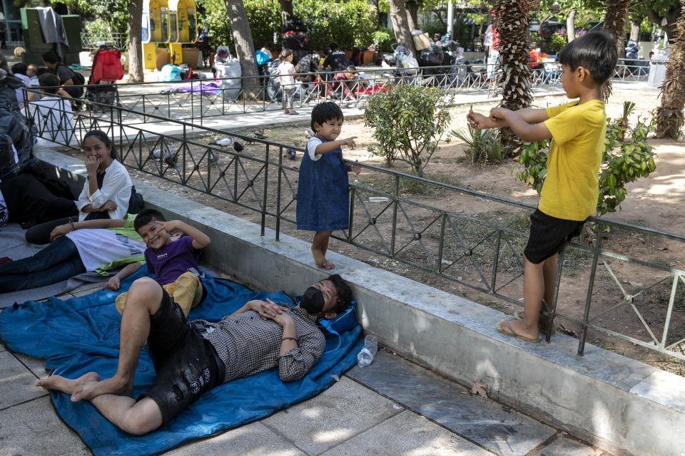 Migrants from Afghanistan with their belongings, sit at central Victoria square in Athens, on Wednesday, Sep. 2, 2020. Greece's Shipping Minister says Greek authorities have managed to prevent the arrival of thousands of migrants seeking to enter Greece clandestinely by sea despite a recent lack of cooperation from the Turkish coast guard. (AP Photo/Yorgos Karahalis)