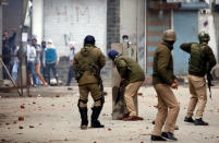 Indian police officers take cover during clashes with Kashmiri demonstrators during a protest against the killing of Zakir Rashid Bhat also known as Zakir Musa, the leader of an al Qaeda affiliated militant group in Kashmir, in Srinagar May 24, 2019. REUTERS/Danish Ismail