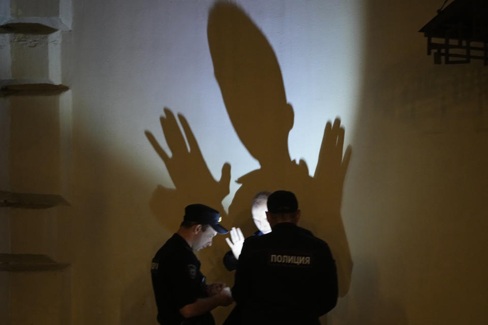 Police officers check documents of a man in central Moscow, Russia, Sunday, June 25, 2023. (AP Photo/Dmitri Lovetsky)