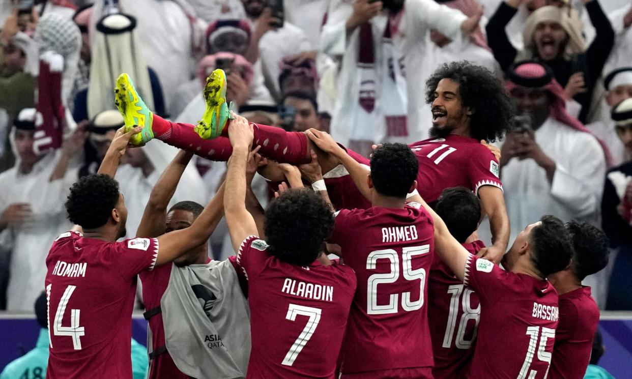 <span>Akram Afif’s teammates throw him up in the air after Qatar’s victory.</span><span>Photograph: Thanassis Stavrakis/AP</span>