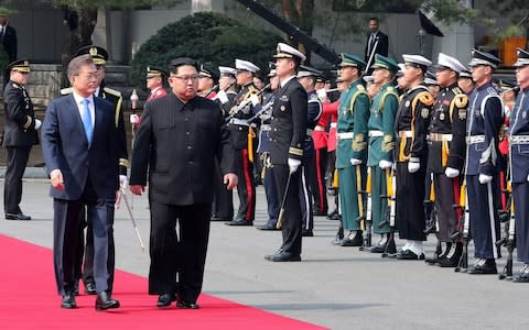 North Korea's leader Kim Jong-un walks with South Korea's President Moon Jae-in past a guard of honour - Credit: AFP