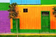 <p>A home exterior in Peru packs a punch with saturated shades of green, orange, and purple.</p>