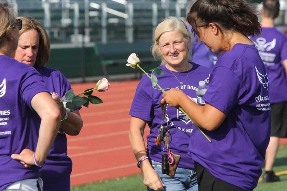 Walkers received roses at the Tournament of Roses Parade Charity Walk at St. Joseph High School on July 19, 2022