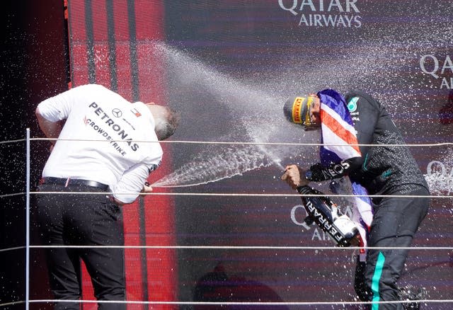 Lewis Hamilton celebrates winning the British Grand Prix by spraying champagne at engineer Peter Bonnington at Silverstone 