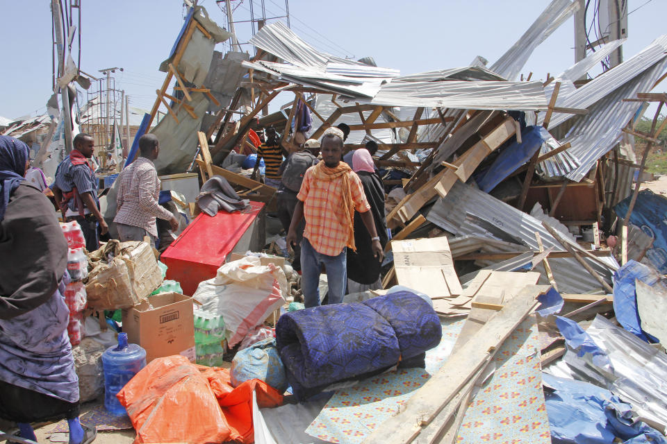 Somalis salvage goods after shops were destroyed in a car bomb in Mogadishu, Somalia, Saturday, Dec. 28, 2019. A truck bomb exploded at a busy security checkpoint in Somalia's capital Saturday morning, authorities said. It was one of the deadliest attacks in Mogadishu in recent memory. (AP Photo/Farah Abdi Warsame)
