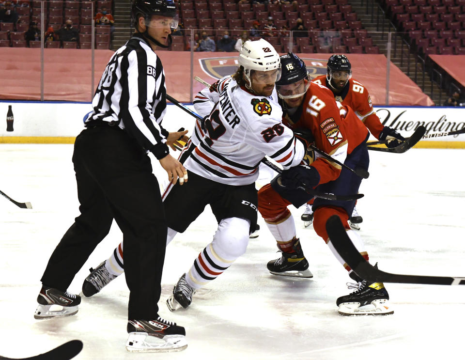 Florida Panthers center Aleksander Barkov (16) battles for position with Chicago Blackhawks center Ryan Carpenter (22) after a face-off during the second period of an NHL hockey game Sunday, Jan. 17, 2021, in Sunrise, Fla. (AP Photo/Jim Rassol)