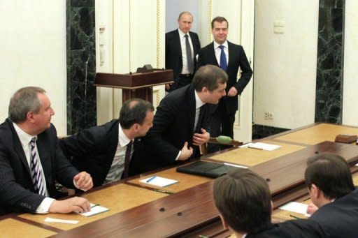 Russian Prime Minister Dmitry Medvedev (top, right) and Russian President Vladimir Putin (top, left) arrive for a meeting of their new cabinet in Moscow on Monday. Putin asserted his command with a new cabinet in which trusted allies will oversee finance while tested veterans keep tight reigns on foreign affairs and defence