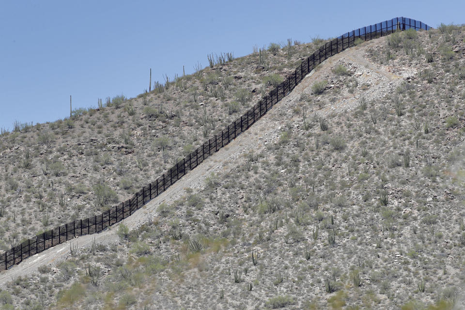 A rugged uphill section of the international border wall that runs through Organ Pipe National Monument is shown, Thursday, Aug. 22, 2019 in Lukeville, Ariz. Construction on a two mile portion of replacement fencing funded by President Trump's national emergency declaration has begun in an area near the official border crossing that runs through Organ Pipe. (AP Photo/Matt York)