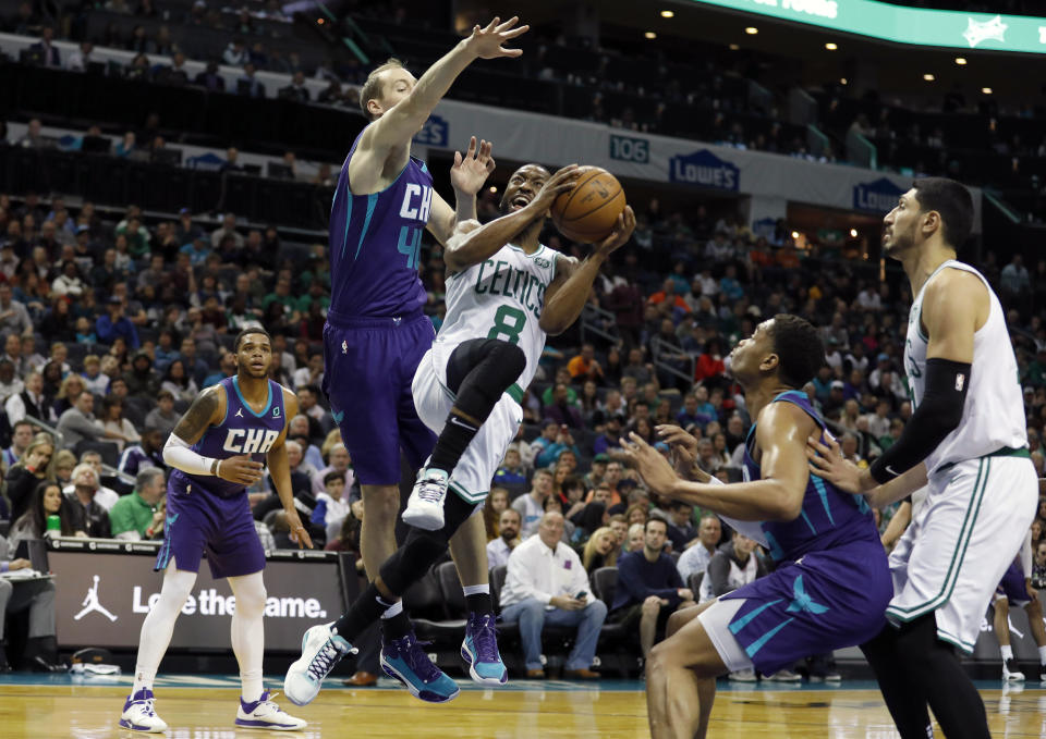 Boston Celtics' Kemba Walker (8) makes a move to try and shoot past Charlotte Hornets' Cody Zeller (40) during the first half of an NBA basketball game in Charlotte, N.C., Tuesday, Dec. 31, 2019. (AP Photo/Bob Leverone)