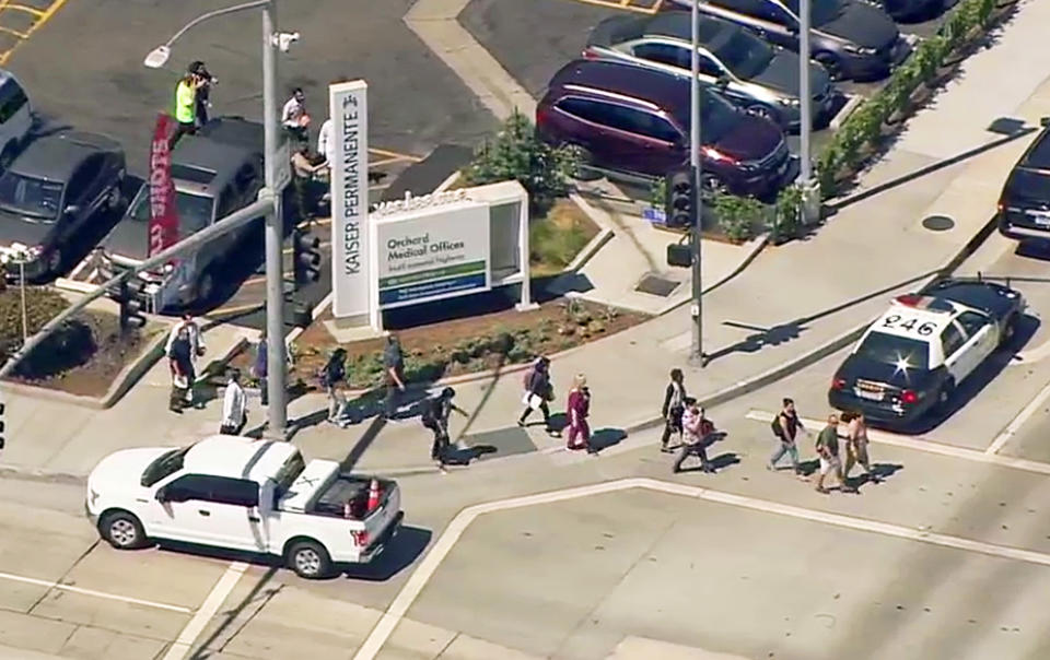 This photo from video provided by ABC7 Los Angeles shows people being evacuated from Kaiser Permanente Downey Medical Center, following reports of someone with a weapon at the facility in Downey, Calif., Tuesday, Sept. 11, 2018. Los Angeles County sheriff's officials say a suspect is in custody and deputies and police officers are methodically searching the complex. (ABC7 Los Angeles via AP)