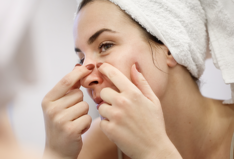 woman popping a face pimple