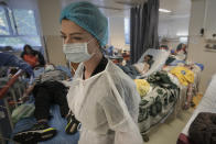 FILE - A member of the medical staff walks in a crowded COVID-19 isolation room at the University Emergency Hospital in Bucharest, Romania, Friday, Oct. 22, 2021. In much of Eastern Europe, coronavirus deaths are high and vaccination rates are low, but politicians have hesitated to impose the measures curb the virus that experts are calling for. A World Health Organization official declared earlier this month that Europe is again the epicenter of the coronavirus pandemic. (AP Photo/Vadim Ghirda, File)