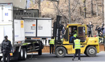 A container containing AstraZeneca's coronavirus vaccines is unloaded from a truck at a distribution center in Icheon, South Korea, Wednesday, Feb. 24, 2021. South Korea's top infectious disease expert has warned that vaccines will not end the coronavirus pandemic quickly as the country prepared to give its first vaccinations this week. (Yonhap via AP)