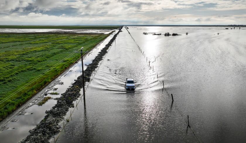 San Joaquin Valley, CA, Thursday, March 30, 2023 - A vehicle braves the flooded Garces Highway as the Tulare Lake basin continues to swell following record rainfall. (Robert Gauthier/Los Angeles Times)