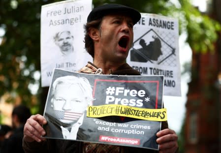 A demonstrator holding a placard protests outside of Westminster Magistrates Court, where a case hearing for U.S. extradition of Wikileaks founder Julian Assange is held, in London