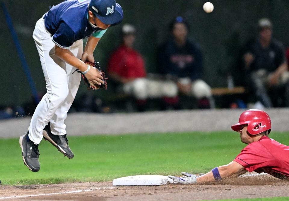 The ball takes a hop on Brewster third baseman Nick Lorusso as Nick Goodwin of Harwich arrives at third safely during a game Friday in Harwich.