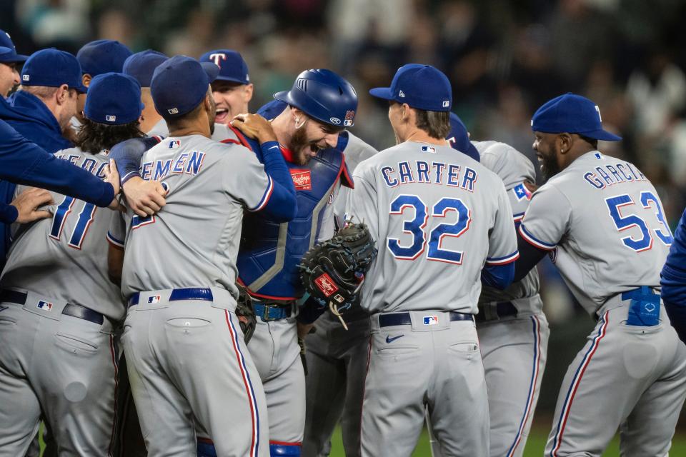 Texas Rangers players celebrate after clinching a postseason berth against the Seattle Mariners at T-Mobile Park in Seattle on Sept. 30, 2023.