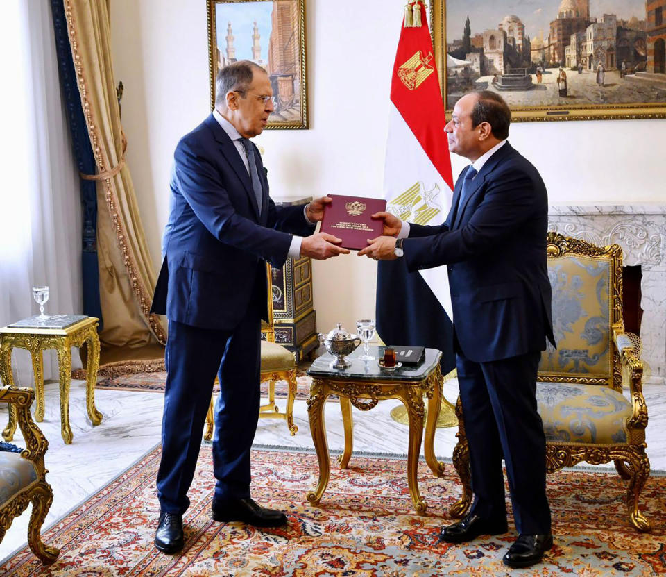 In this handout photo released by the Egyptian presidency, President Abdel Fattah el-Sissi and Russian Foreign Minister Sergey Lavrov hold a document during a meeting Sunday, July 24, 2022, in Cairo, Egypt. (Egyptian Presidency via AP)