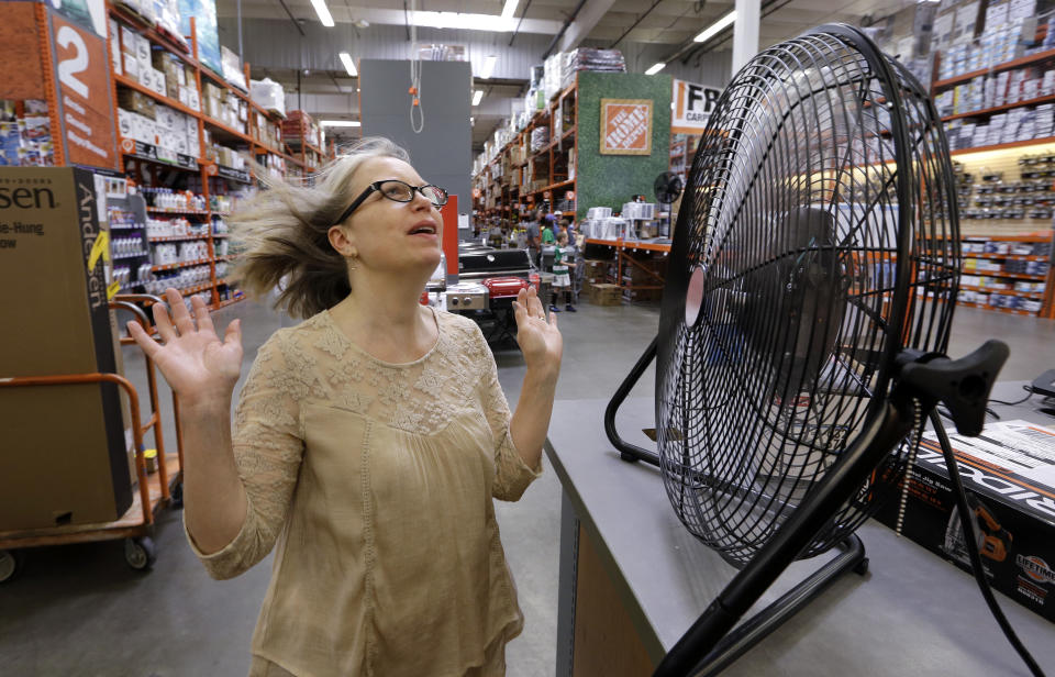 Davi Sobotta holds up her hands as she tries out the last, large tabletop fan available at a Home Depot hardware store ahead of an expected heat wave Tuesday, Aug. 1, 2017, in Seattle. An excessive heat warning for the area began Tuesday afternoon and continues through Friday evening, as unusually hot weather will bring temperatures nearing a peak of 100 degrees on Thursday. (AP Photo/Elaine Thompson)