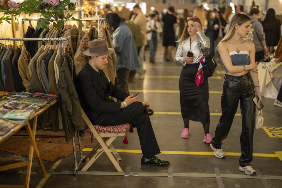 A clothes seller waits for customers in a market in Kyiv, Ukraine, Sunday, April 28, 2024. (AP Photo/Francisco Seco)