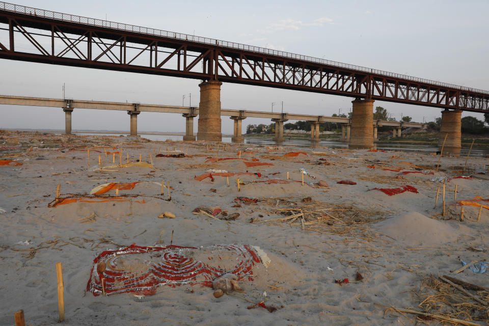 Bodies of suspected coronavirus victims are seen in shallow graves buried in the sand near a cremation ground on the banks of Ganges River in Prayagraj, India, Saturday, May 15, 2021. (AP Photo/Rajesh Kumar Singh)