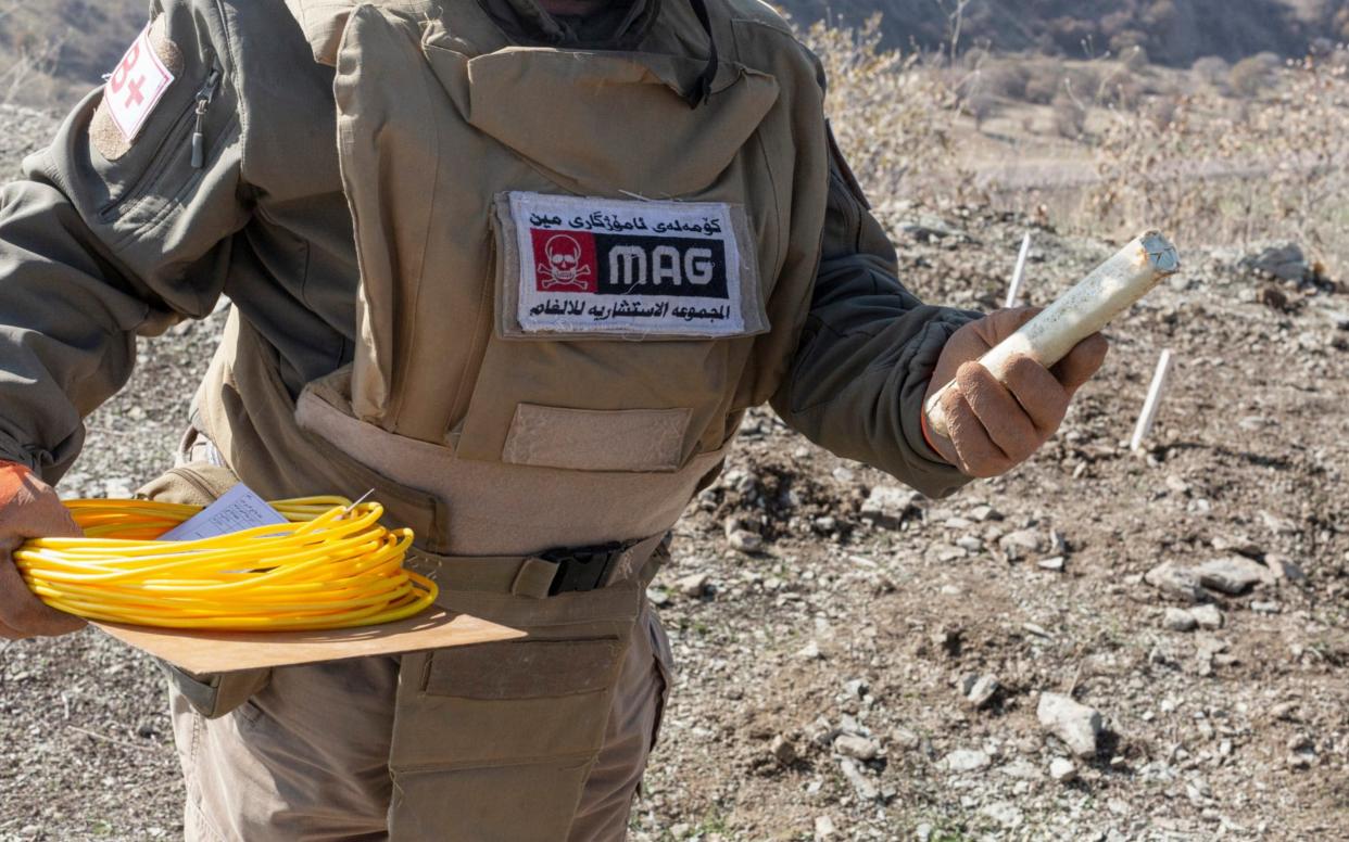 A Mine Advisory Group de-miner holds an explosive with which he will detonate landmines planted during the Iran-Iraq war, near the Iranian border in Iraq - Sam Tarling /Sam Tarling 