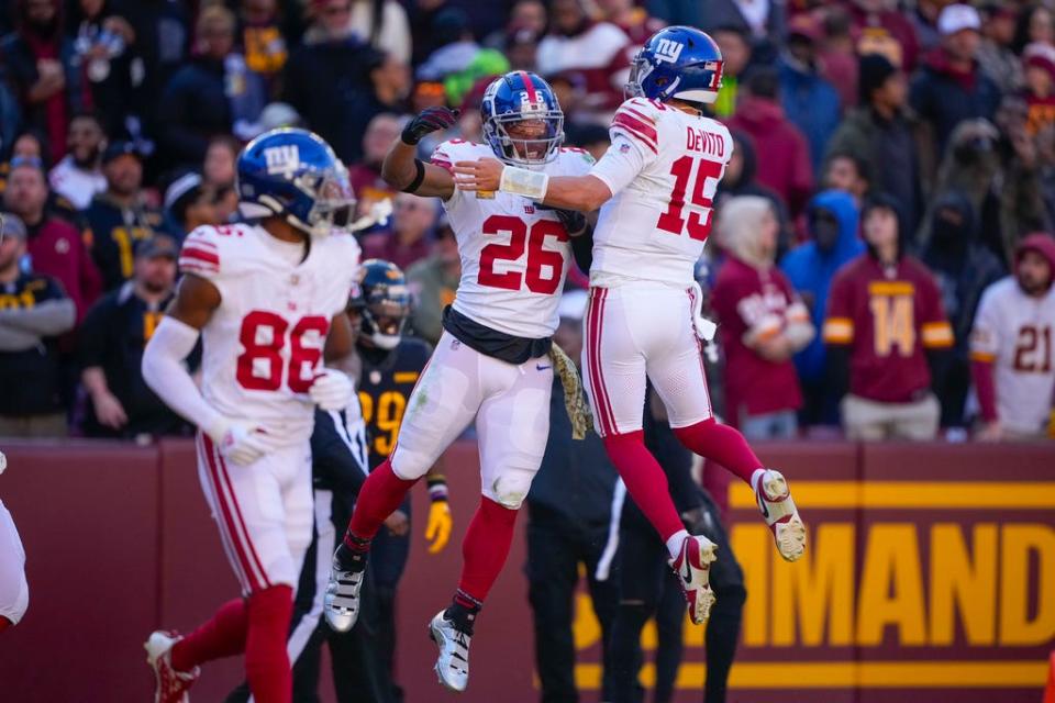 New York Giants running back Saquon Barkley (26) celebrating his touchdown against the Washington Commanders with quarterback Tommy DeVito (15) during the first half of an NFL football game, Sunday, Nov. 19, 2023, in Landover, Md. (AP Photo/Andrew Harnik)