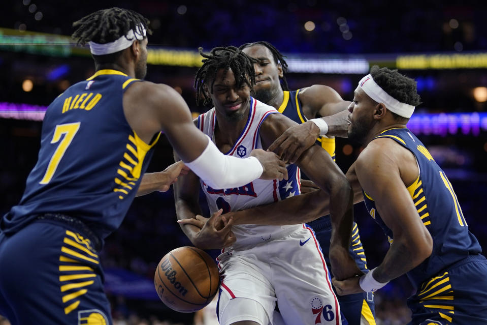 Philadelphia 76ers' Tyrese Maxey, center, cannot hang onto a loose ball against Indiana Pacers' Buddy Hield, from left, Aaron Nesmith and Bruce Brown during the second half of an NBA basketball game, Sunday, Nov. 12, 2023, in Philadelphia. (AP Photo/Matt Slocum)