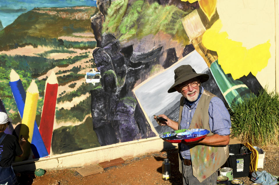 Illustrator Steve Ferchaud paints a mural commemorating the Camp Fire, Thursday, Oct. 26, 2023, in Paradise, Calif. (AP Photo/Noah Berger)