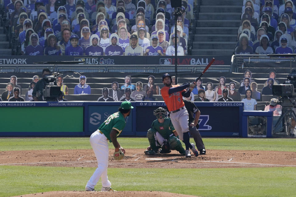 Houston Astros' George Springer, right, watches his two-run home run off of Oakland Athletics pitcher Sean Manaea, left, during the third inning of Game 2 of a baseball American League Division Series in Los Angeles, Tuesday, Oct. 6, 2020. (AP Photo/Marcio Jose Sanchez)