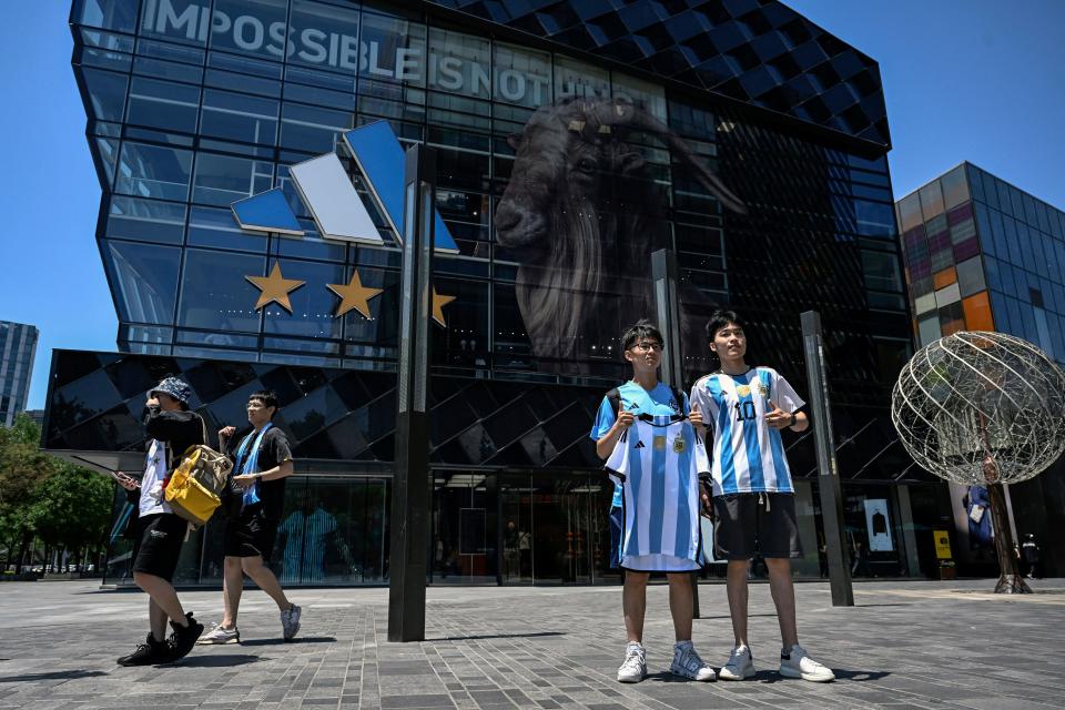 Chinese fans holding a football jersey showing the number of Argentinian star Lionel Messi pose for photos in front of an Adidas store in Beijing on June 13, 2023. Argentina will play a friendly football match against Australia on June 15 at Beijing's newly-renovated 68,000-capacity Workers' Stadium. (Photo by Jade GAO / AFP) (Photo by JADE GAO/AFP via Getty Images)