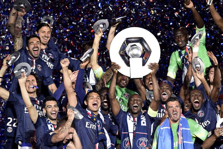 Paris Saint-Germain defender Zoumana Camara (C) holds up the Ligue 1 trophy after defeating Reims to take the title at the Parc des Princes stadium on May 23, 2015