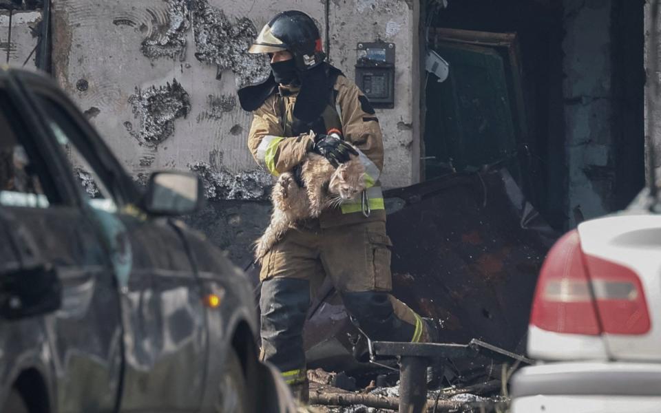 A rescuer carries a cat out from a residential building heavily damaged by a Russian missile strike in Kryvyi Rih, Dnipropetrovsk region - ALINA SMUTKO/REUTERS