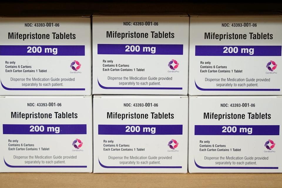 Boxes of drugs labeled mifepristone sit on a shelf