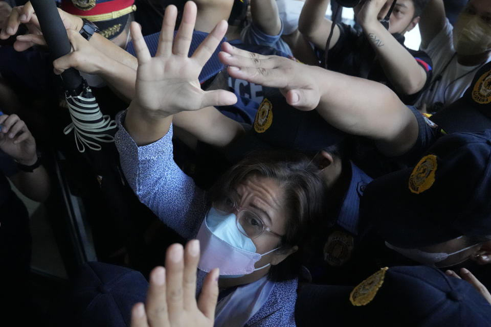 Detained former opposition Sen. Leila de Lima waves under tight security as she arrives to attend a court hearing which later postponed in Muntinlupa, Philippines, Monday, Oct. 10, 2022. Human rights activists pressed their call Monday for the immediate release of de Lima after she was taken hostage in a rampage by three Muslim militants in a failed attempt to escape from a maximum-security jail. (AP Photo/Aaron Favila)