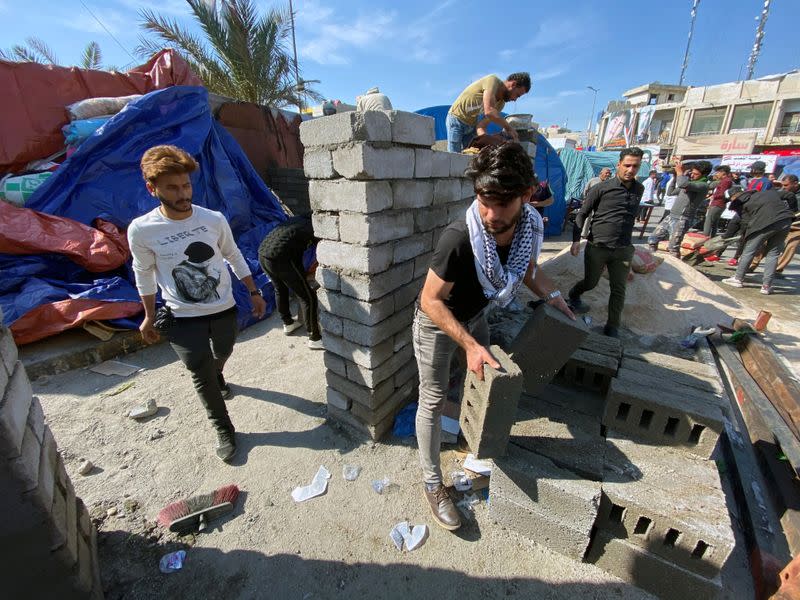 Iraqi demonstrators build camps with bricks to replace tents that were set on fire by unidentified gunmen during ongoing anti-government protests in Nassiriya