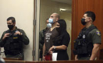 Former UFC heavyweight champion Cain Velasquez, center, with his attorney Alexandra Kazarian, makes an initial court appearance at the Santa Clara County Hall of Justice on Wednesday, March 2, 2022, in San Jose, Calif. Velasquez was arrested Monday on suspicion of attempted murder after he allegedly shot a man in Northern California, police said. (Aric Crabb/Bay Area News Group via AP, Pool)