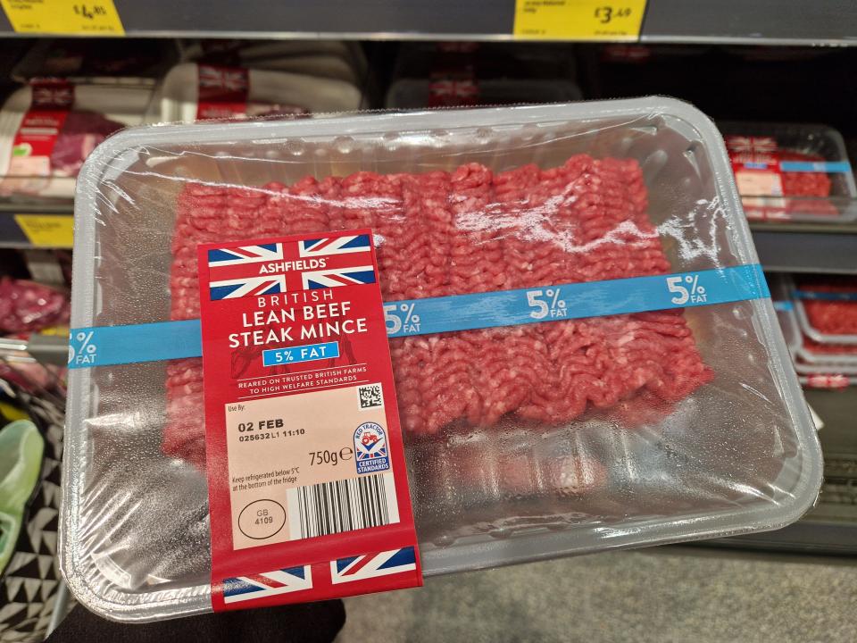 The writer holds a pack of ground beef with a Union Jack flag on label