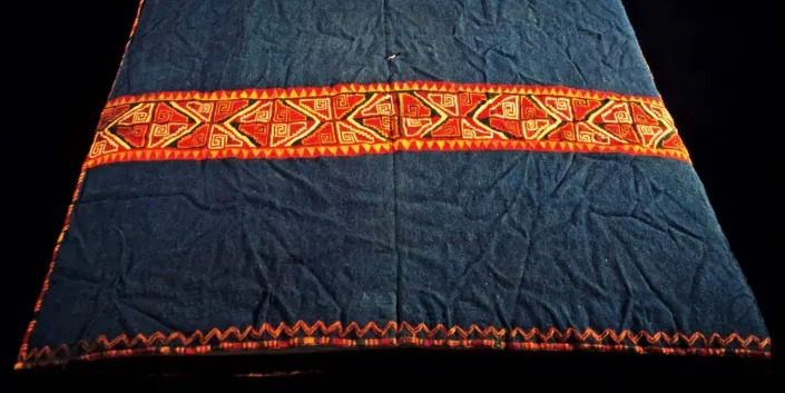 A colourful deep blue cloth with a orange stripe across the bottom.