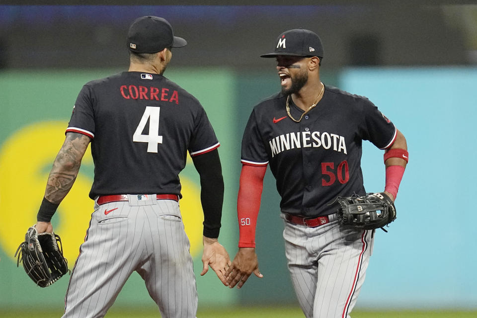 Minnesota Twins' Carlos Correa (4) and Willi Castro (50) celebrate after the Minnesota Twins defeated the Cleveland Guardians in a baseball game Tuesday, Sept. 5, 2023, in Cleveland. (AP Photo/Sue Ogrocki)